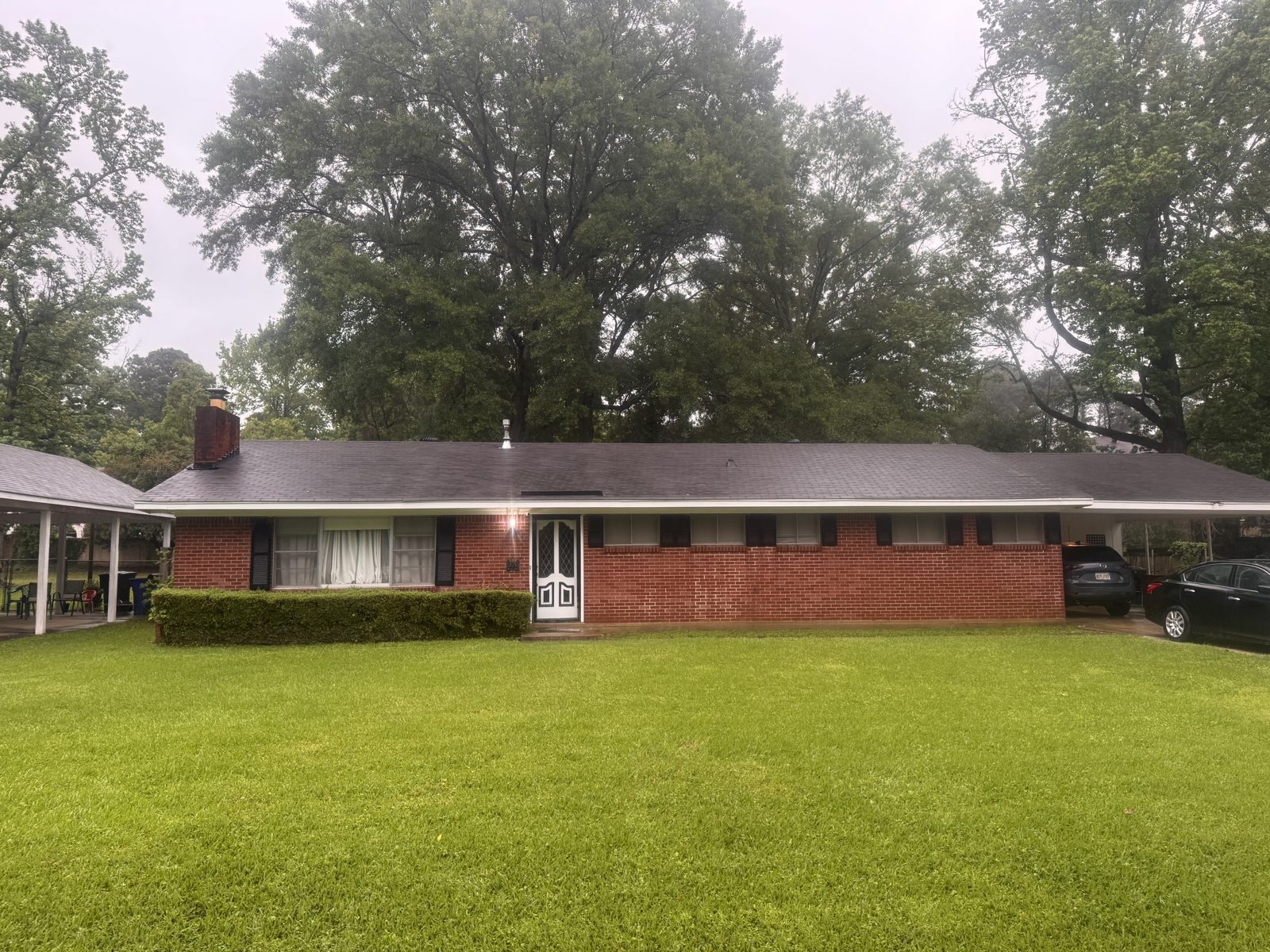 Long red brick ranch home with clean white fascia and trim after a house wash, Ark-La-Tex region