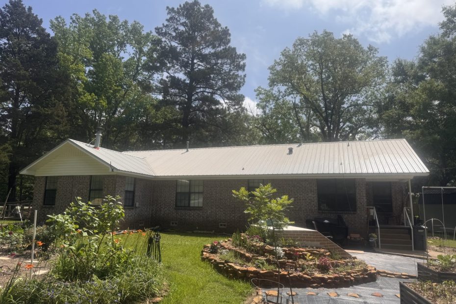 Brick ranch home with a light metal roof and rock landscaping beds in Haughton, LA