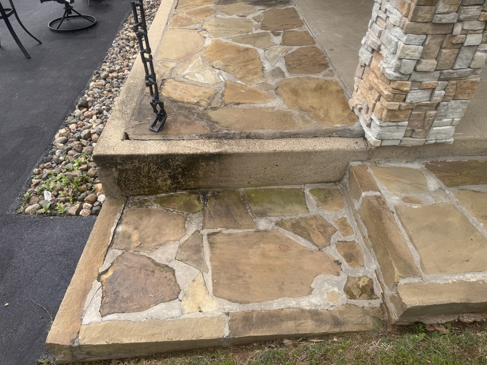 Flagstone steps and a stacked stone column beside an asphalt drive, Ark-La-Tex region