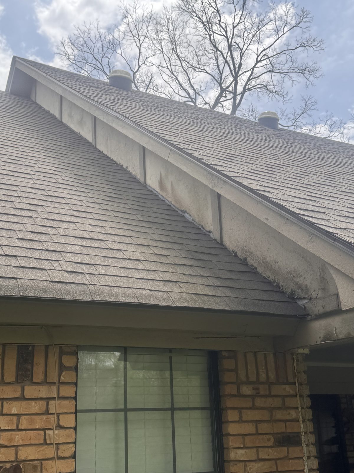 Asphalt shingle roof edge and gutter over a brick wall in Haughton, LA